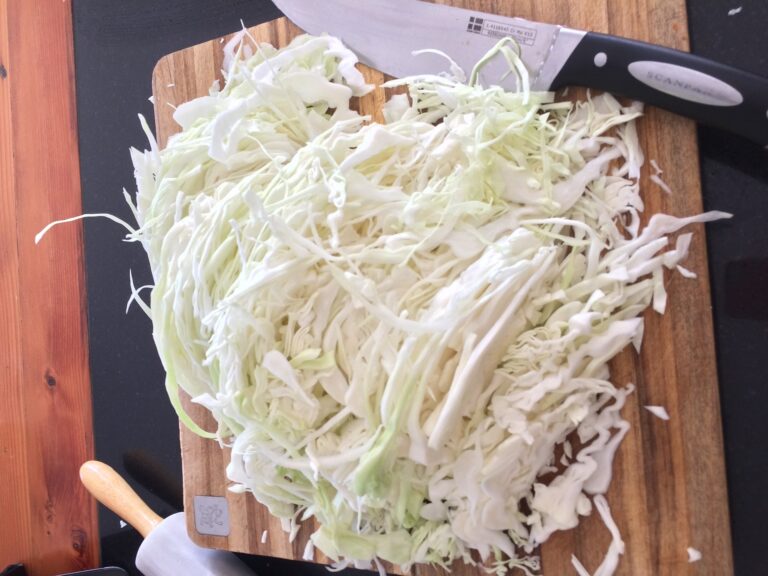 Shredded cabbage sitting on a cutting board