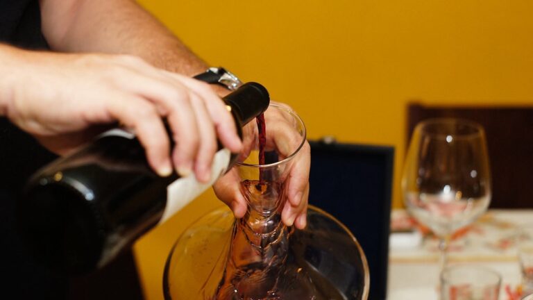 Man's hand decanting a bottle of wine