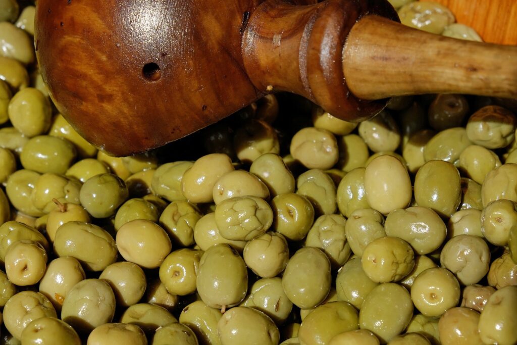 green olives fermenting in wooden container