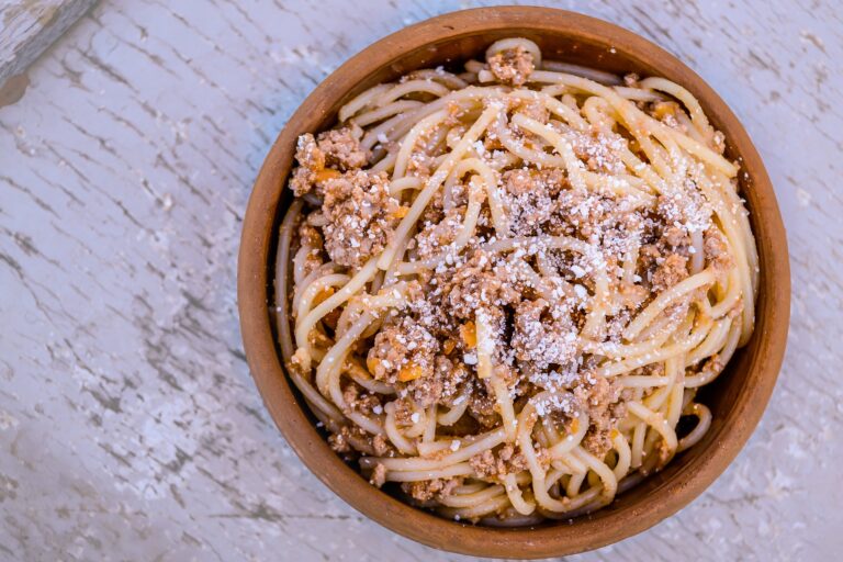 Bowl of spaghetti topped with Parmesan cheese