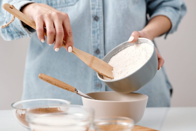 A person purring flour into a baking bowl